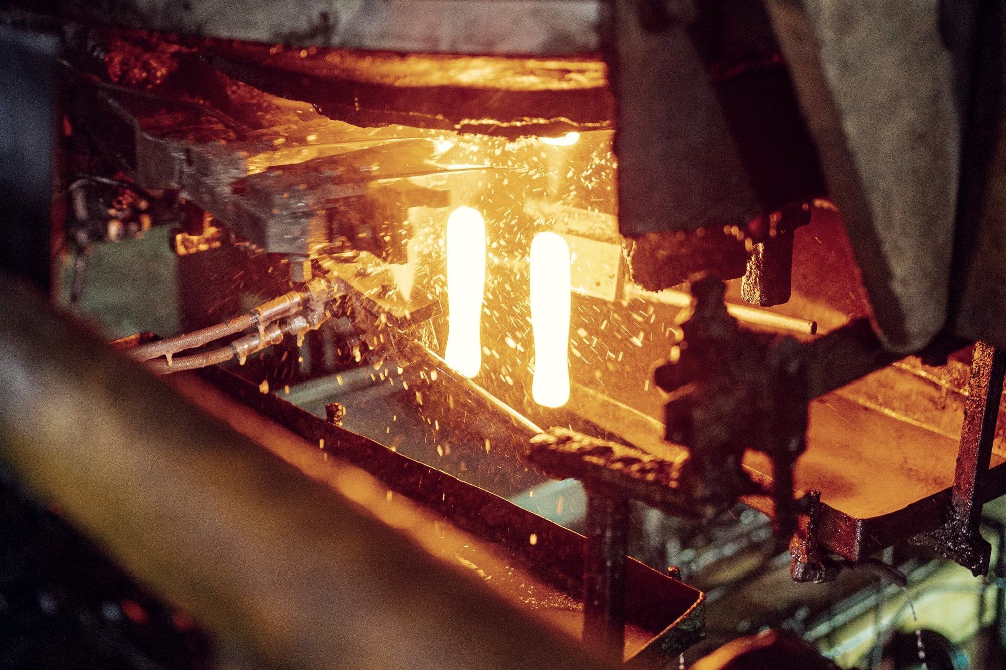 Glowing steel bars inside an industrial furnace